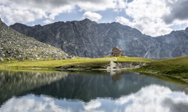 Rocky mountain peaks of the Panargenkamm and mountain hut Neue Reichenberger Hütte, mountain lake