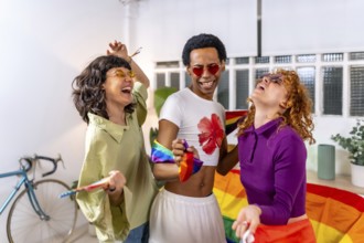 Happy friends celebrating pride party at home dancing and laughing together