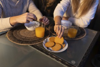 Couple having breakfast together, enjoying orange juice and biscuits, starting their day with a