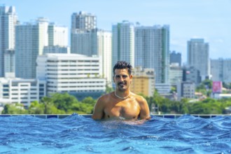 Tourist enjoying refreshing swim in rooftop infinity pool with breathtaking view of cebu city