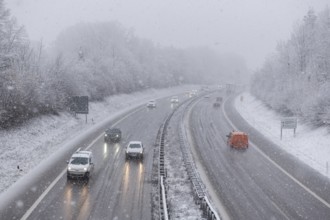 Vehicles travelling on a wintery, tree-lined and snow-covered road, Winnenden, Baden-Württemberg,