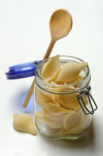 Conchiglione in glass jar with cooking spoon, Italian pasta variety