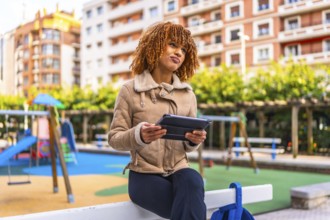 Creative latin young woman working with digital tablet while expressing doubts with face in an