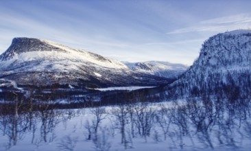 Vast snow-covered mountain landscape under a blue sky, Norway, Europe
