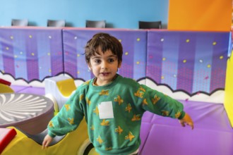 Preschooler enjoying playtime in a vibrant and stimulating indoor play area, promoting early