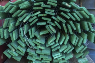 Close-up of rolled fluorescent green painted wood and steel wire snow fence in outdoor storage