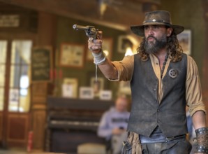 Western actor (sheriff with colt) in the saloon of the western village Fort Bravo or Texas