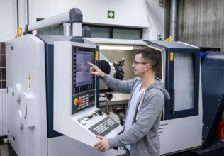 Remscheid, North Rhine-Westphalia, Germany - Trainee in metalworking, here at a CNC machine tool,