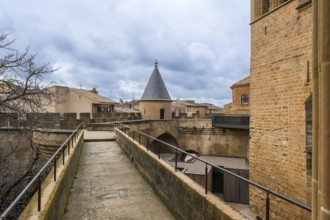 Stone walkway and watchtower rising above the rooftops of olite, offering breathtaking views of the