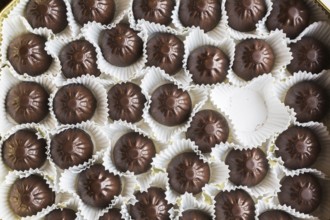 Top view and close-up of opened chocolate box with one chocolate missing or eaten, Studio