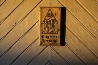 Pilgrims and Olav the Saint or Olav II Haraldsson with axe, Pilgrims Hostel lettering, wooden