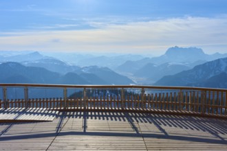Wooden platform with a view of snow-covered mountains under a blue sky, Steinplatte, Waidring,