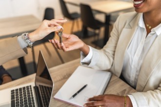 Real estate agent handing over keys to a new homeowner, symbolizing a successful property purchase