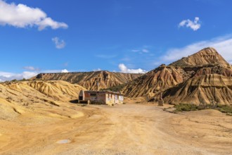 Scenic view of an abandoned, graffiti covered building rising from the arid bardenas reales desert