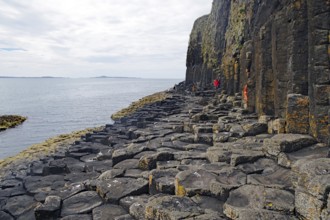 Majestic rock formation with basalt columns on a rugged coastline by the sea, Staffa, Hebrides,