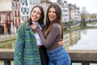 Friends visiting a city enjoying standing together next to a river