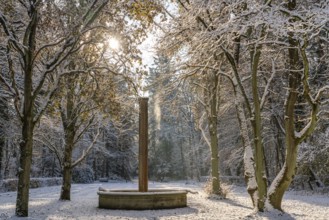 Fountain and snow-covered trees in the sunlight, south-west churchyard, historic cemetery in