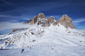 View of a ski resort piste with people skiing in Dolomites in Italy