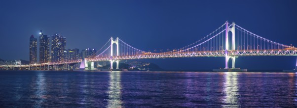 Panorama of Gwangan Bridge and skyscrapers illuminated in the night. Busan, South Korea, Asia