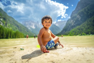 Smiling child playing with a toy car on the shore of lake landro, also called durrensee, in the