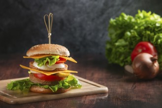A burger on a wooden board, with fresh ingredients in the background in a rustic ambience