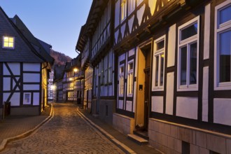 Narrow alley with half-timbered houses and cobblestones in the old town centre in the evening,
