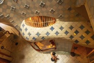 High angle view of a tourist capturing the colorful ceramic tiles and curved staircase design