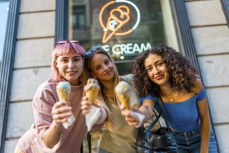 Three beauty different woman holding delicious ice creams outside the store