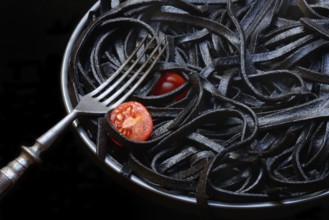 Black pasta coloured with squid ink on a plate, Taglioni al Nero di Seppia, Italy, Europe