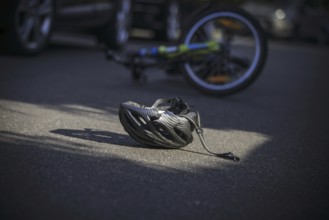 Symbol photo on the subject of bicycle accidents (posed scene) . A broken bicycle helmet lies next