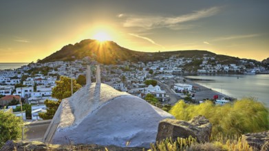 Agia Paraskevi Chapel, Small chapel at sunset with a view of a coastal town and the sea in the