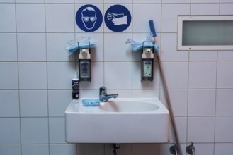Washroom for workers in a company, hygiene measures, liquid soap and hand sanitiser