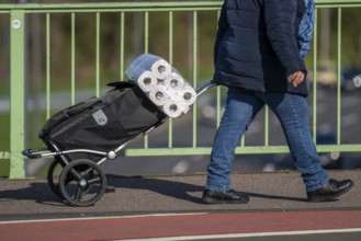 Effects of the coronavirus crisis, woman bought a large pack of toilet paper, Cologne, Germany,