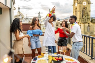Young man dancing with multi-ethnic friends in rooftop during birthday party