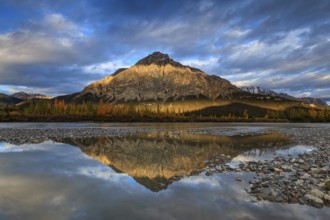 Clouds and evening light over mountains, mountain reflected in water, autumn, Brooks Range, Alaska,