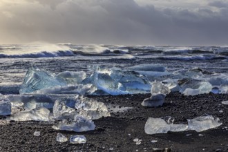 Ice floes on the beach, waves, sea, clouds, sunlight, winter, Diamond Beach, Breidamerkursandur,