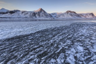 Ice floes on a lake in front of snowy mountains, ice, sun, evening light, snow, winter,