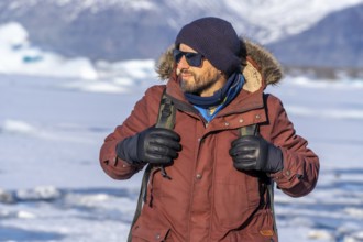 Portrait of a hiker walking on the frozen lake of Jokulsarlon glacier in Iceland