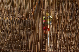 Construction site, reinforced concrete construction site, workers erect a mesh of reinforcing bars,