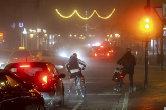 Cyclist, darkness, inner city traffic, Rüttenscheider Straße, bicycle lane, fog, autumn, winter,