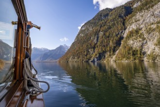 A trumpet is played on the echo wall of a tourist boat, Königssee, autumnal mountain landscape