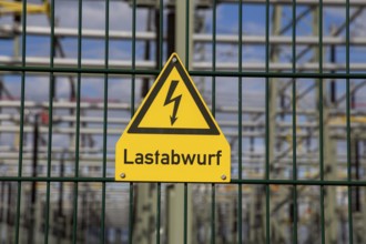 Symbolic image: The word load shedding is written under a sign that usually warns of high voltage