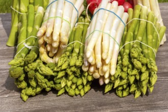 Green asparagus and white asparagus decorated on a rustic wooden table