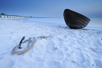 Small wooden boat anchored on the beach of the Baltic Sea, Weststrand Darß, long exposure after