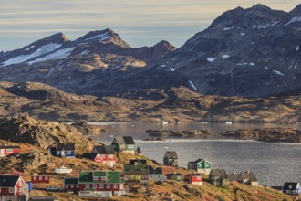 Typical Greenlandic houses on a fjord with steep mountains, Inuit settlement, autumn, Tasiilaq,