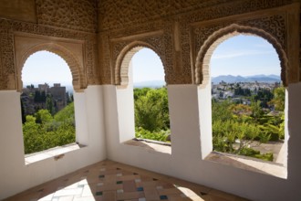 Arched decorated Moorish stone windows looking over gardens, Generalife garden, Alhambra, Granada,