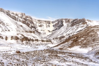 The beautiful Hengifoss waterfall frozen in the cold winter of Iceland, volcanic cliffs