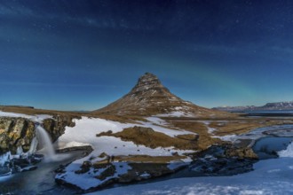 Long exposure of Kirkjufell snowy mountain and its beautiful waterfall in Icelandic winter