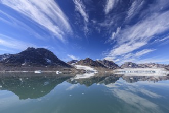 Glaciers and mountains reflected in fjord, sunny, East Greenland, Greenland, North America