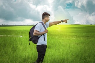 Adventurous man in the field, man with backpack in the field looking